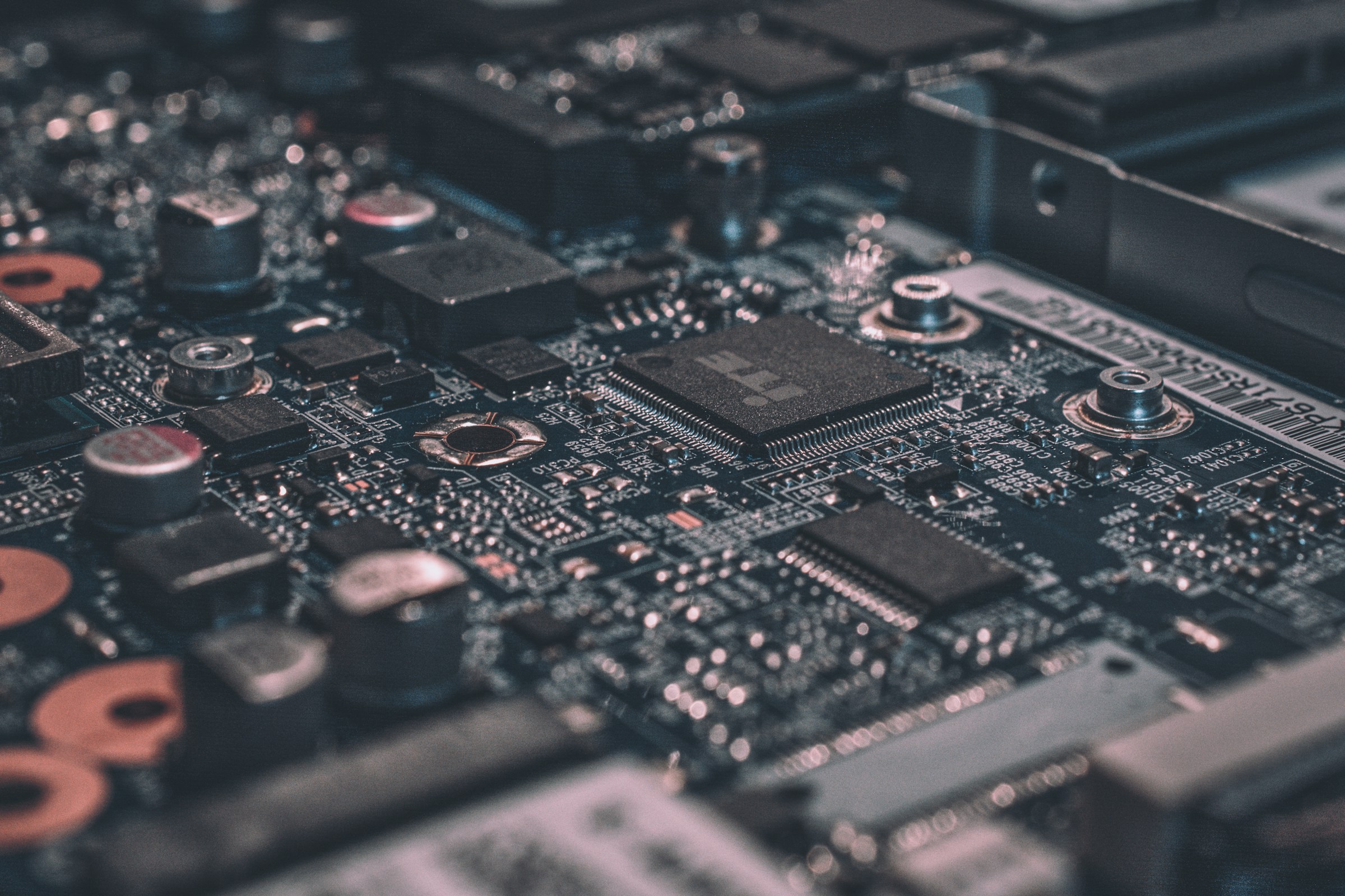Macro view of a dark circuit board with copper coils and microprocessors